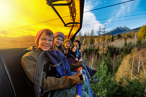 Mother and three teenage kids riding on chairlift in the mountains on a autumn day. Tatra Mountains, Slovakia.

Canon R5