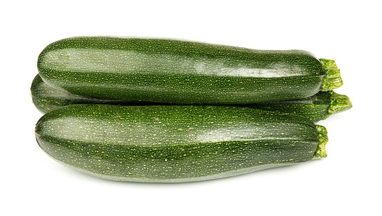 Fresh green zucchini on a white background, vegetables close-up.