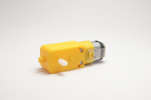 A yellow gearbox motor side view on a white background. DIY materials for the electronics hobbyist
