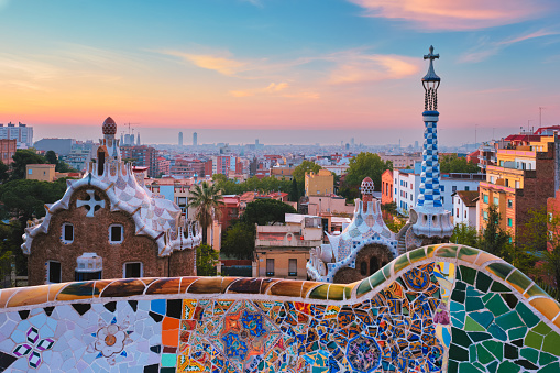 Barcelona, Spain - April 17, 2019: Barcelona city view from Guell Park with colorful mosaic buildings in tourist attraction Park Guell in the morning on sunrise. Barcelona, Spain