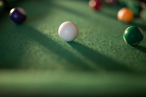 white billard ball on green background with copy space