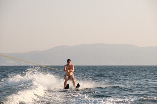 Man waterskiing on sea at summer