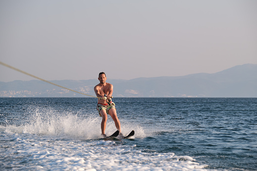 Man waterskiing on sea at summer