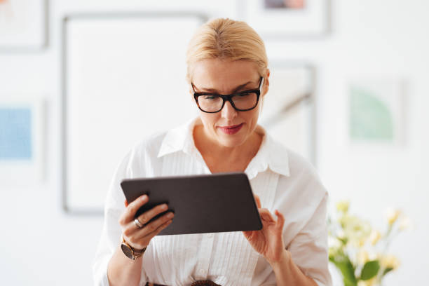 istock Smiling Businesswoman Using A Digital Tablet At Work 1441983661