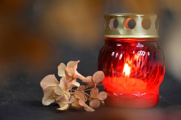 istock Burning candle and dry hydrangea flower on dark background. Sympathy card 1441983787