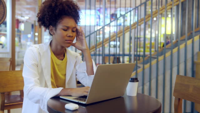 Young Entrepreneur stressed and headaches while using laptop in a co-working space