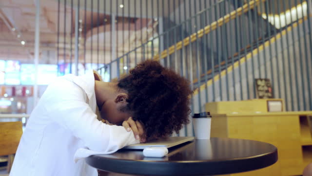 Young Entrepreneur stressed and headaches while using laptop in a co-working space