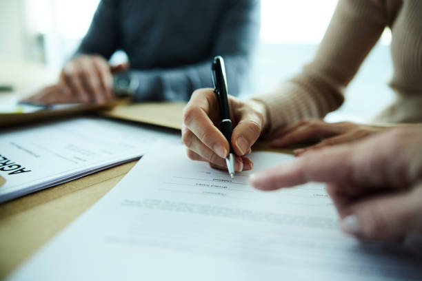 Signing a contract! Close up of unrecognizable woman signing a contract in the office. lease agreement stock pictures, royalty-free photos & images