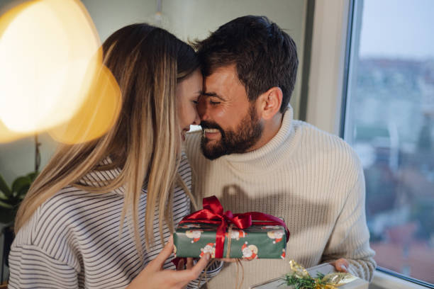 istock Excited young couple opens Christmas gifts 1441986882