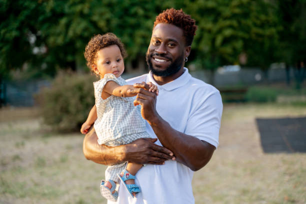 istock Joyous young man with his child in a park 1441987062