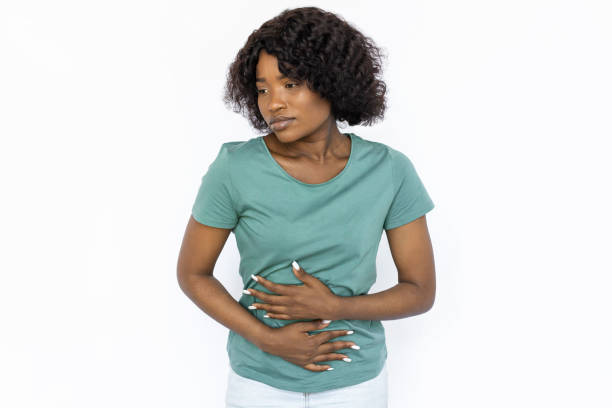 istock Sad young woman holding her stomach 1441987523