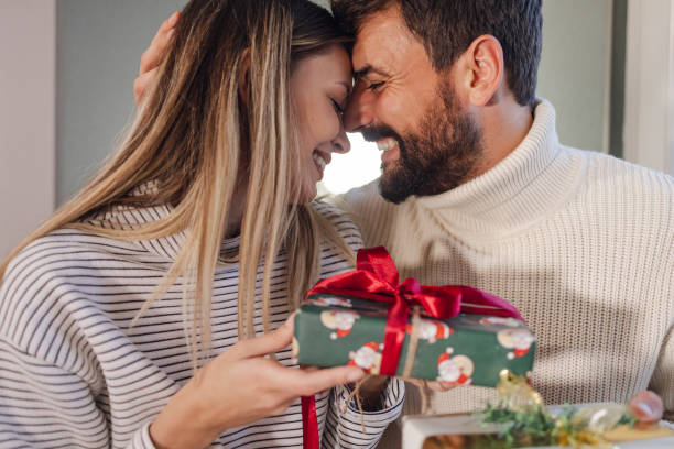 istock Excited young couple opens Christmas gifts 1441988941