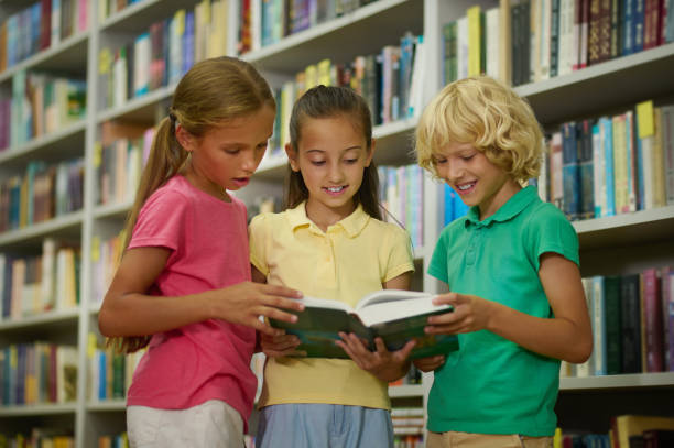 istock Happy classmates spending time in the school library 1441990250