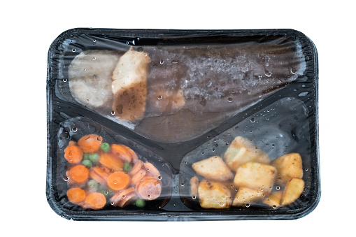 Frozen chicken dinner inside its container and plastic film