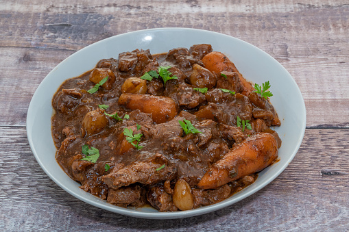 Beef casserole cooked in the slow cooker and served on a white plate