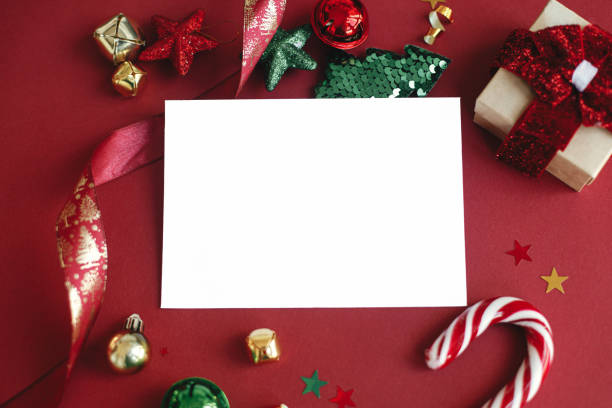 istock Christmas card mock up. Modern greeting card composition with christmas decorations and gift on red background. Empty postcard template with space for text. Happy Holidays! 1441993505