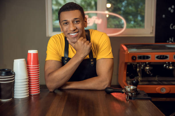 istock Smiling happy barista posing for the camera in the workplace 1441996575