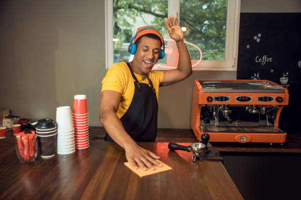 istock Merry coffee shop worker wiping the table with a cloth 1441996583