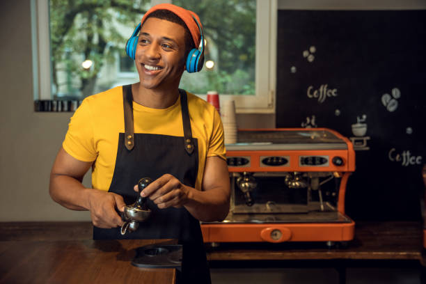 Cafe worker making a caffeinated drink to his favorite music