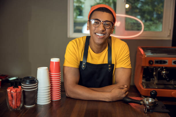 istock Smiling happy barista posing for the camera in his workplace 1441996826