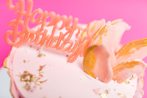 Birthday cake with pink cream and happy birthday decoration
