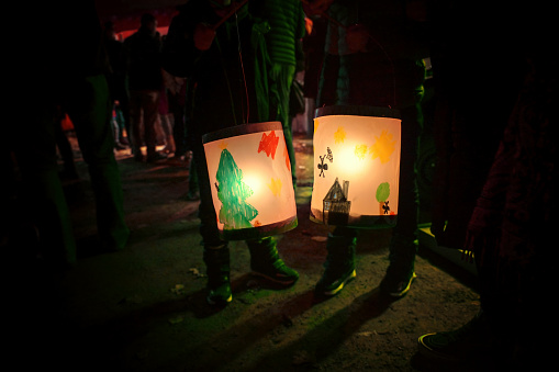 Homemade lanterns painted by children on a traditional procession of lights on st. martin's day at night, copy space, selected focus, narrow depth of field