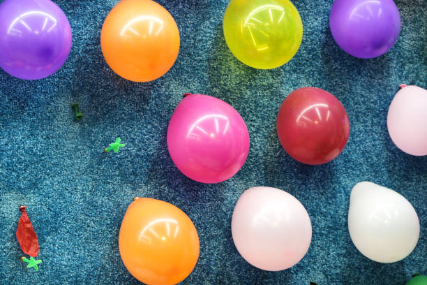 dardo de globo en una pared, dos globos se revientan, lanzando juego en la feria de carnaval, enfoque seleccionado, - rubber dart fotografías e imágenes de stock