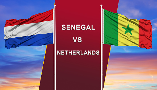 Senegal vs. Netherlands  two flags on flagpoles and blue cloudy sky background.Soccer matchday template