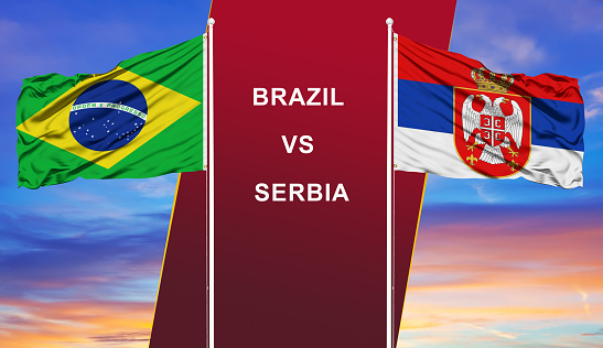 Brazil vs. Serbia two flags on flagpoles and blue cloudy sky background.Soccer matchday template