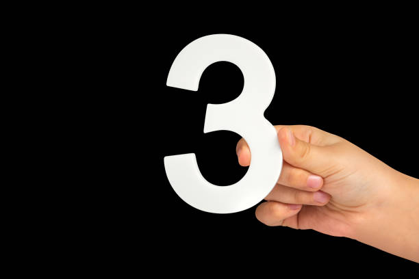 istock number three in hand isolated on black background. Number three in a child's hand on a black background. To be inserted into a project or design. 1442002263
