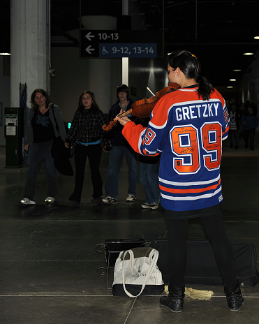 Toronto, Canada - November 13, 2011:  Busker wearing autographed Wayne Gretzky jersey plays fiddle in the pathway of Union Station near Air Canada Centre, home of the NHL Toronto Maple Leafs