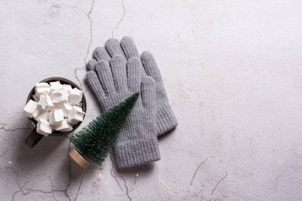 istock Cocoa with marshmallows, woolen gloves and a Christmas tree on plaster. Top view. 1442002825