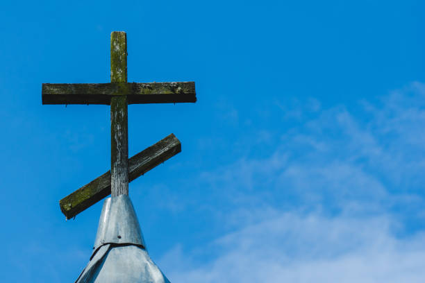 istock Brown wooden cross against blue sky wiht copy space 1442005370