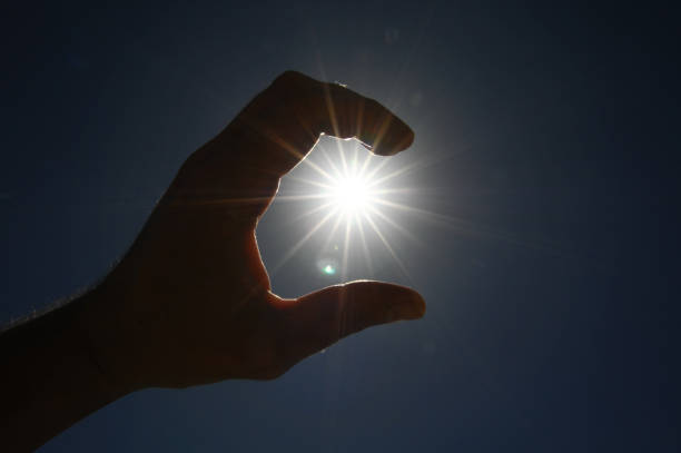 istock One Hand Catching the Sun Stars on a Blue Background 1442006649