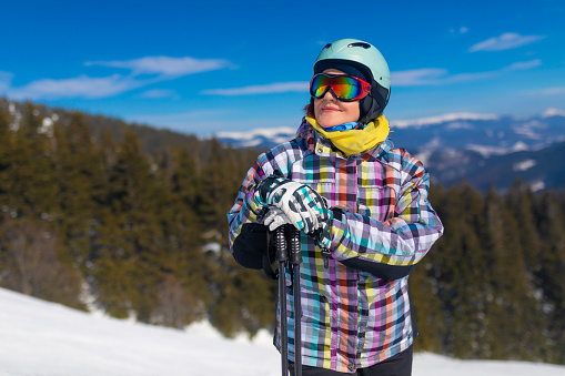 Woman in ski clothing at a ski resort on a sunny winter day