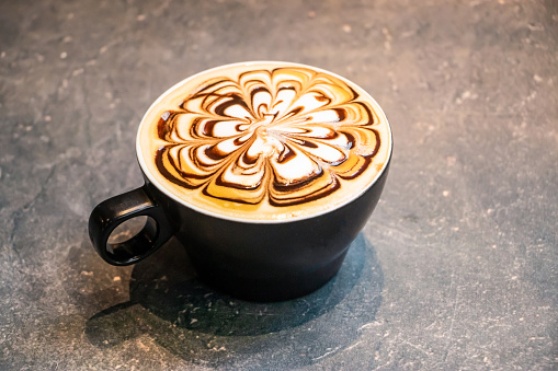 Moca con latte art servido en una taza aislada sobre fondo gris oscuro vista superior de café caliente photo