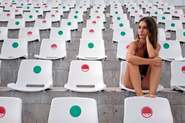 경기장에 혼자 앉아 있는 젊은 여자의 초상화 - stadium empty seat women 뉴스 사진 이미지