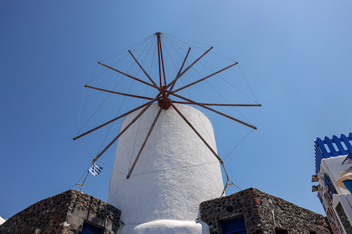 Oia, Santorini, Greece - July 3, 2021: Traditional white windmill in Oia on the island of Santorini. Cyclades, Greece