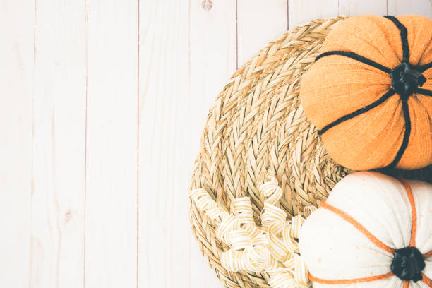 istock Pretty fall autumn flat lay, with fabric pumpkins and a rattan placement on a wood background 1442013194