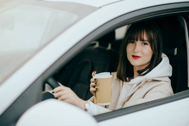 istock Young woman using phone in the car 1442013512