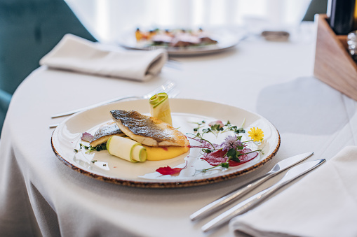 Delicious gourmet meals on a white plates on table in luxury restaurant.