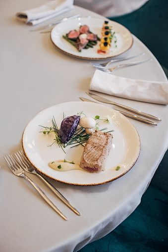 Delicious gourmet meals on a white plates on table in luxury restaurant.