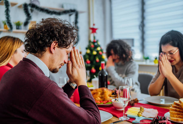 istock Friends praying before eating Christmas lunch 1442016616