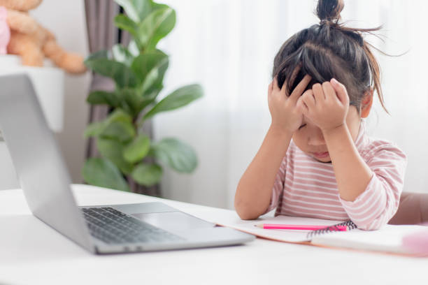 istock Asian child is serious about studying homework during online lesson at home, social distancing during quarantine, self-isolation, online education concept, homeschooling, study online video call teacher. 1442018675