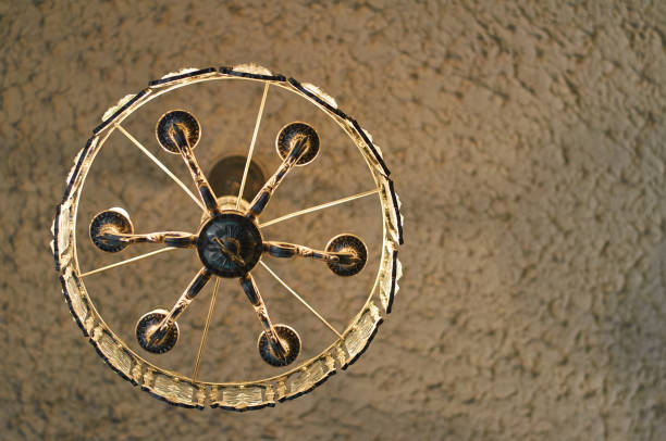 Antique chandelier hangs on the ceiling. View from below. Bulb lightings.