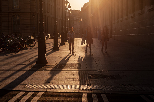 Paris, France - July 16, 2022: Paris Street Scene of unrecognizable people walking at sunset