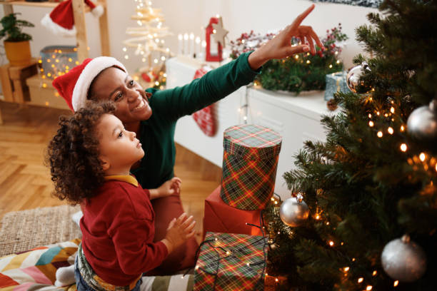 istock Cute little boy decorating Christmas tree with his mother 1442023771