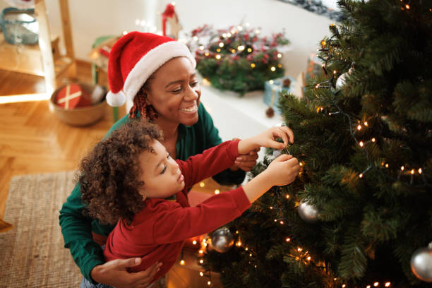 istock Cute little boy decorating Christmas tree with his mother 1442023825