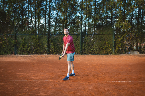 Tennis player with racket during a match game prepares to serve a tennis ball
