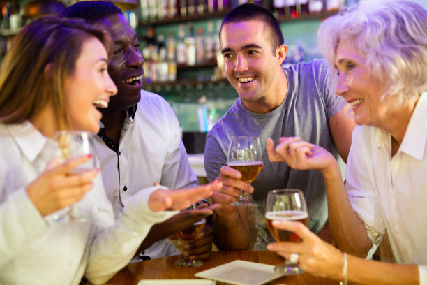 istock Diverse people talking and laughing drinking beer at a bar table 1442025766